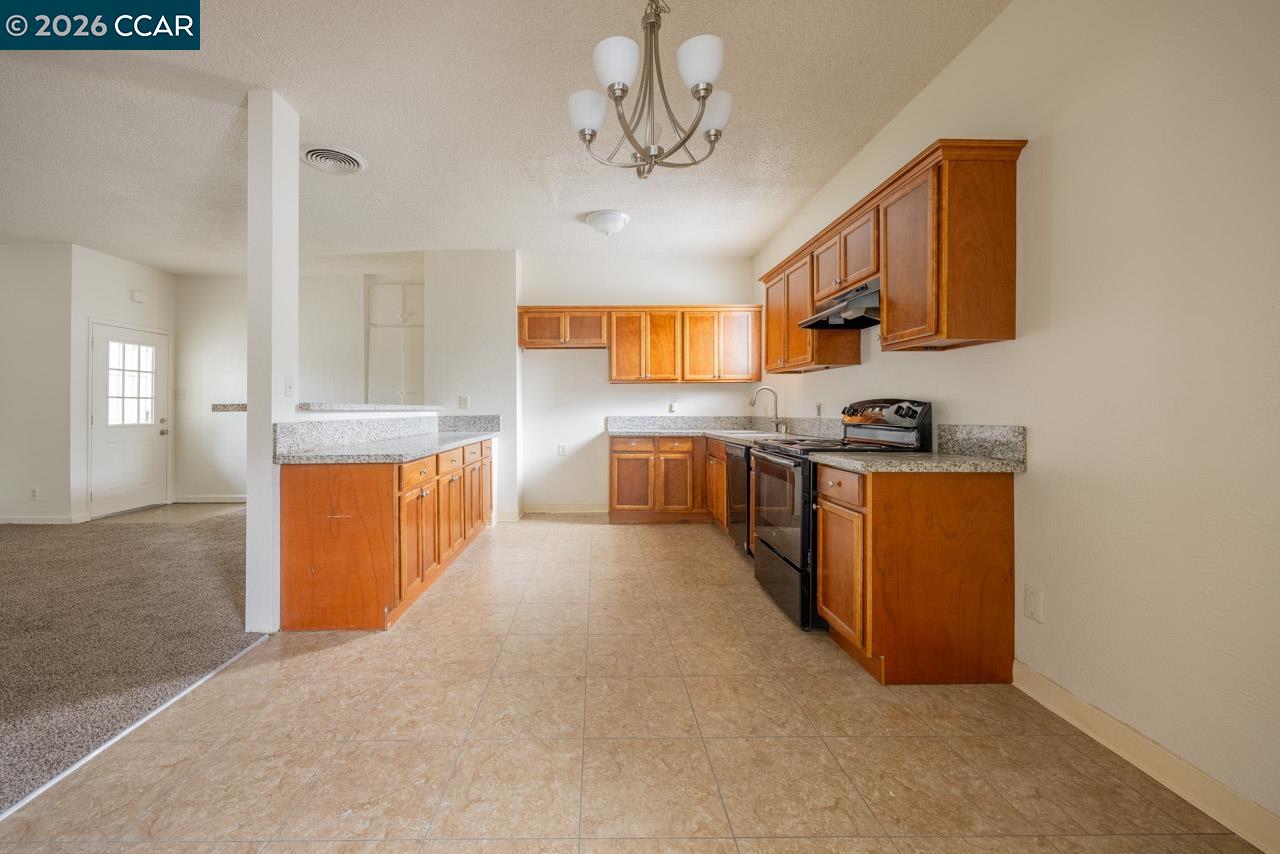 6118 Rutland Drive Carmichael, CA 95608 - Photo 7 of 19 a large kitchen with stainless steel appliances granite countertop a stove oven and a refrigerator with wooden floor