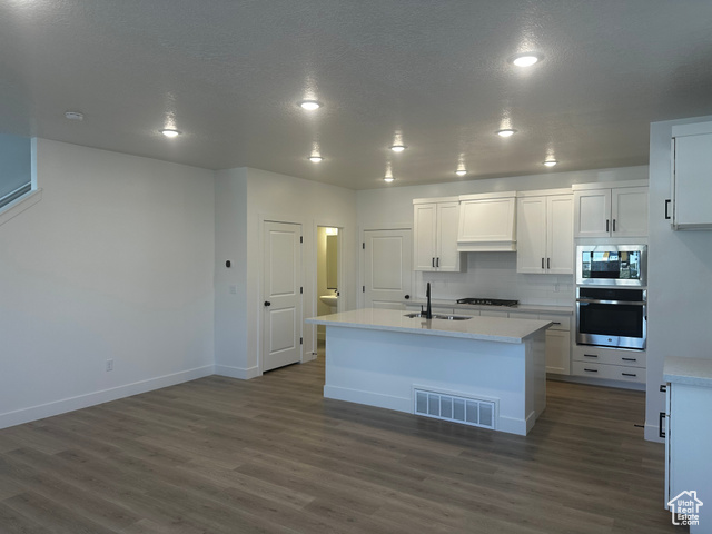 22 South Starlight Lane Mapleton, UT 84664 - Photo 3 of 17 Kitchen featuring appliances with stainless steel finishes, dark wood-style flooring, white cabinets, light countertops, and recessed lighting