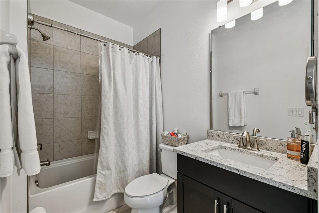 1039 Davis Heather Circle Seffner, FL 33584 - Photo 13 of 27 a bathroom with a granite countertop sink toilet and shower