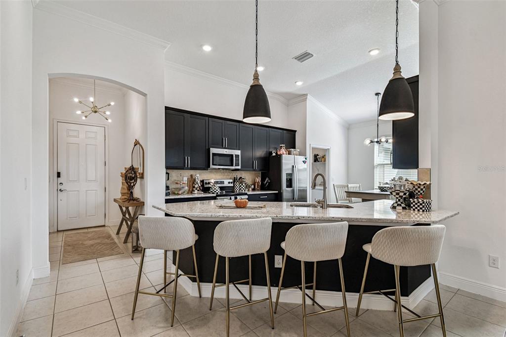 1039 Davis Heather Circle Seffner, FL 33584 - Photo 6 of 27 a kitchen with stainless steel appliances a dining table chairs stove and cabinets