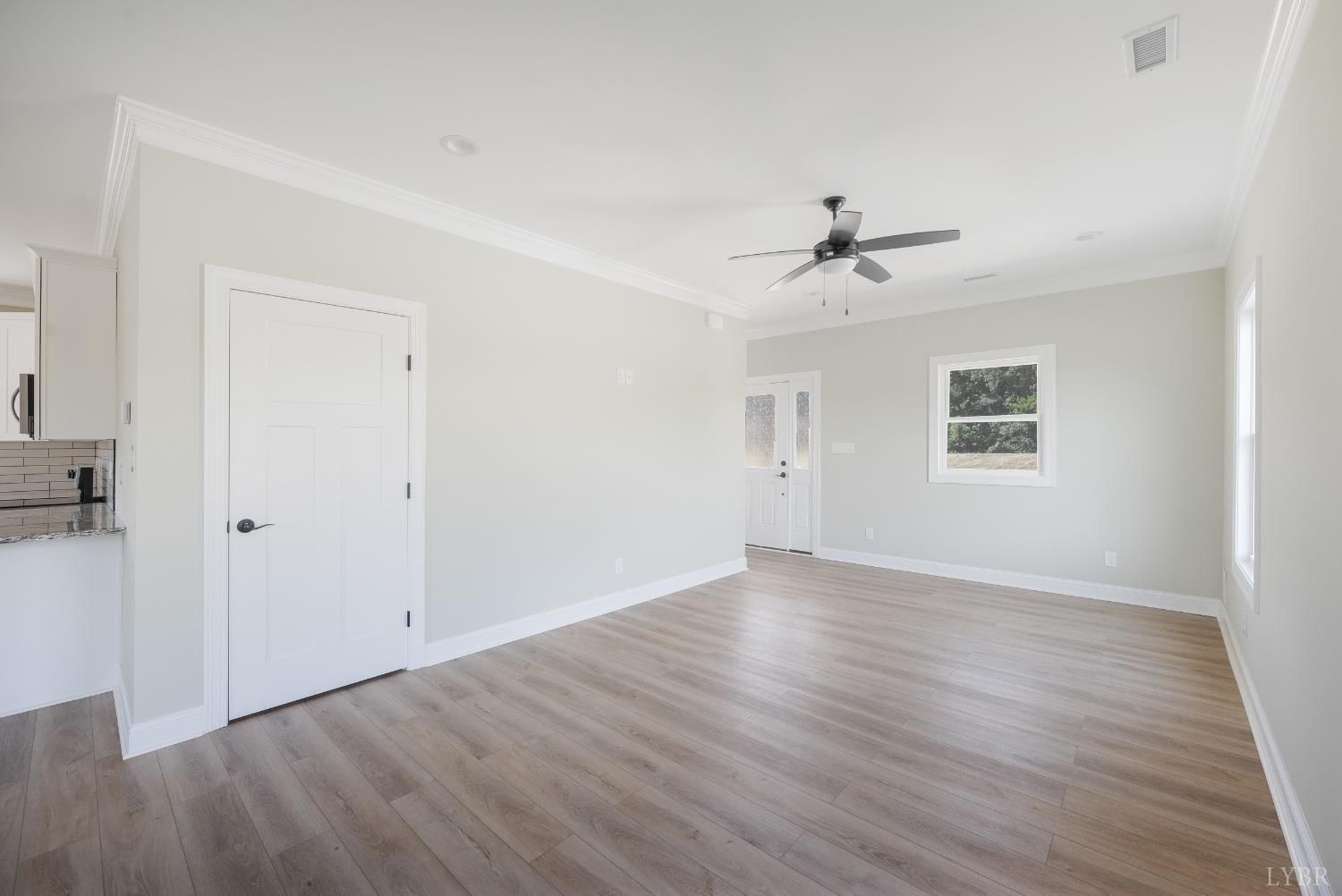 272 Marshall Mill Road Gladys, VA 24554 - Photo 12 of 71 an empty room with wooden floor ceiling fan and windows