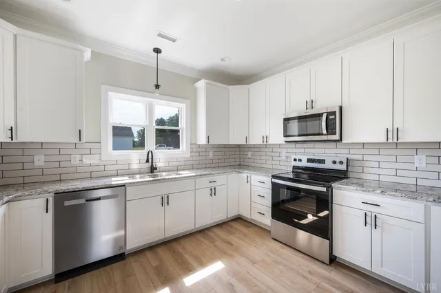 a kitchen with granite countertop white cabinets and white appliances