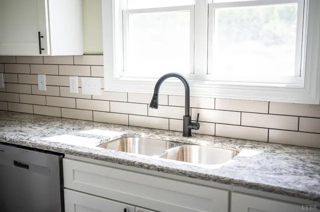 a kitchen with granite countertop a sink a counter space appliances and cabinets