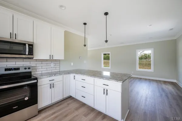 a kitchen with granite countertop a stove sink and cabinets