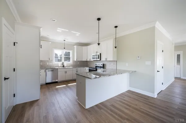 a kitchen with stainless steel appliances granite countertop a sink a stove and cabinets