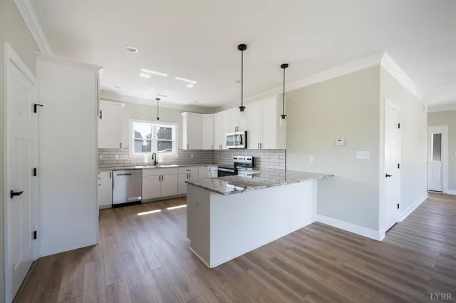 a kitchen with stainless steel appliances granite countertop a sink a stove and cabinets
