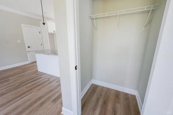 an empty room with wooden floor ceiling fan and windows