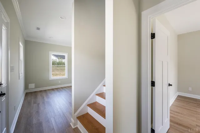 an empty room with wooden floor ceiling fan and windows