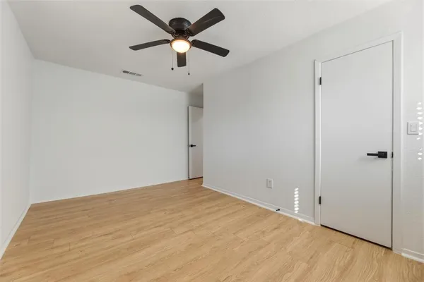 an empty room with a window and a ceiling fan