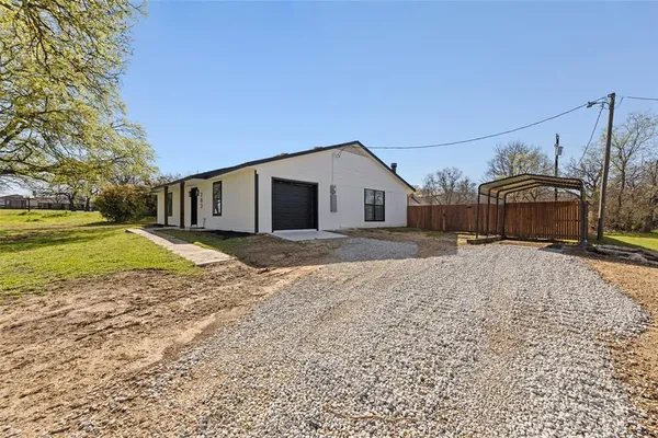 a view of a house with backyard and trees
