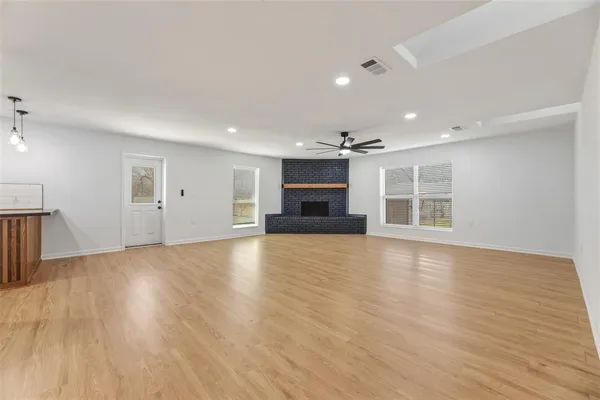 a view of empty room with wooden floor and fireplace