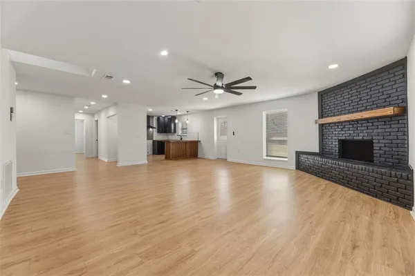 a view of empty room with wooden floor and fireplace