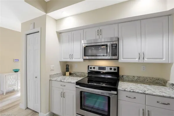 a kitchen with cabinets stainless steel appliances and a counter space