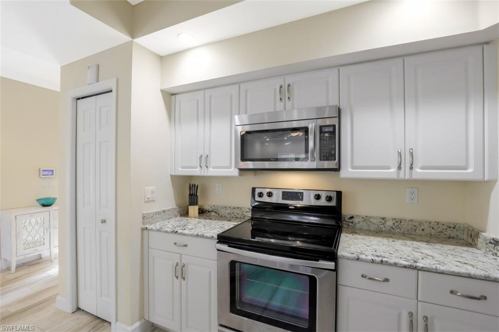 1240 Shady Rest Lane, Unit 102 Naples, FL 34103 - Photo 11 of 23 a kitchen with cabinets stainless steel appliances and a counter space