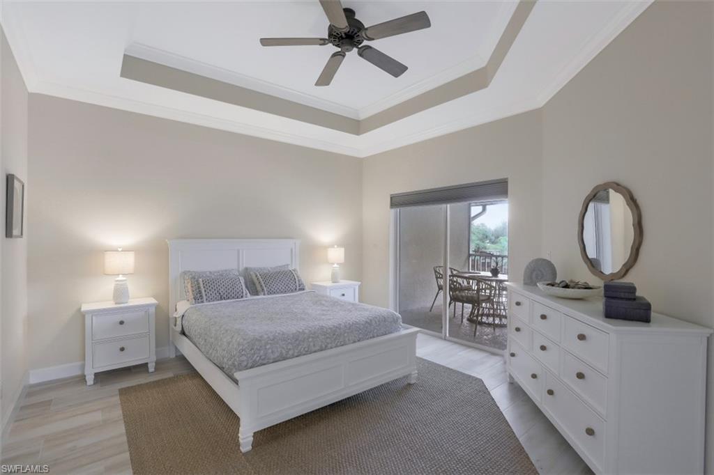 1240 Shady Rest Lane, Unit 102 Naples, FL 34103 - Photo 12 of 23 a bedroom with bed and a chandelier