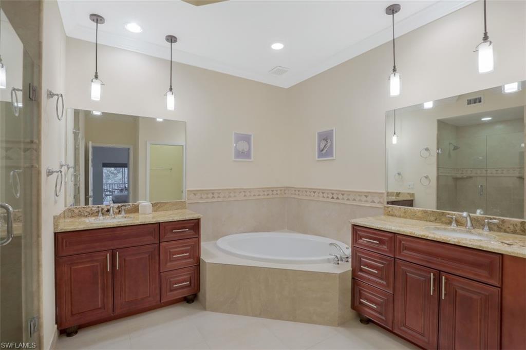 1240 Shady Rest Lane, Unit 102 Naples, FL 34103 - Photo 13 of 23 a bathroom with a tub a sink double vanity and a mirror