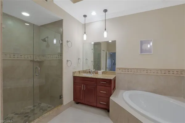a spacious bathroom with a shower a sink and a mirror