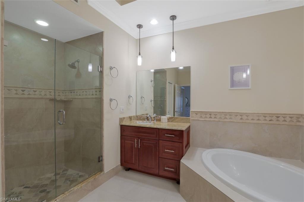 1240 Shady Rest Lane, Unit 102 Naples, FL 34103 - Photo 14 of 23 a spacious bathroom with a shower a sink and a mirror
