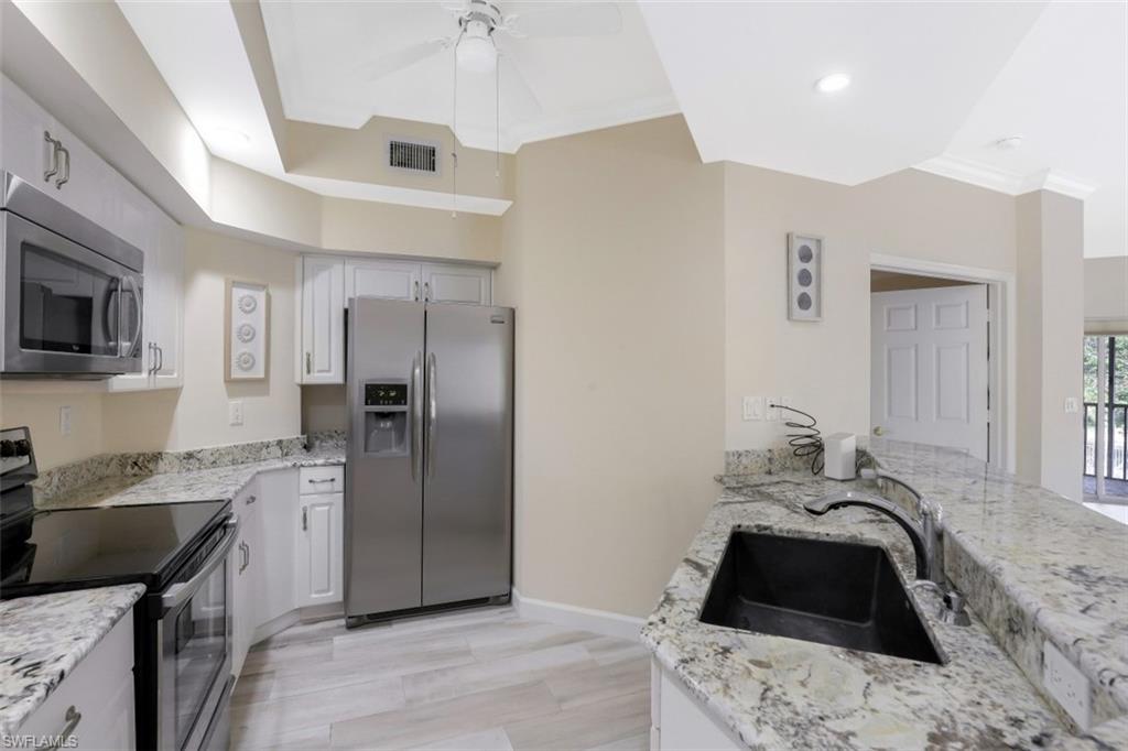 1240 Shady Rest Lane, Unit 102 Naples, FL 34103 - Photo 10 of 23 a bedroom with a bed and a flat screen tv