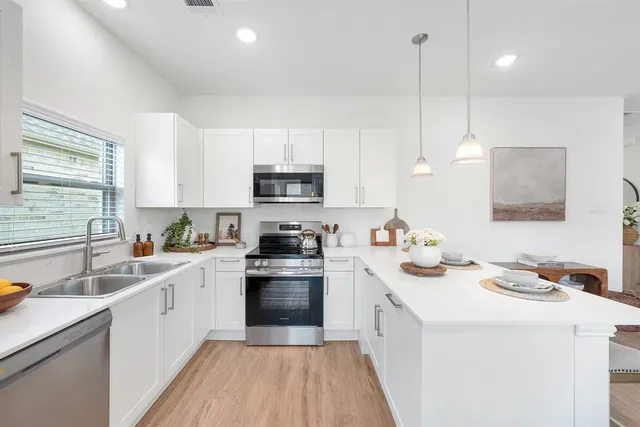 a kitchen with a sink stove top oven and microwave