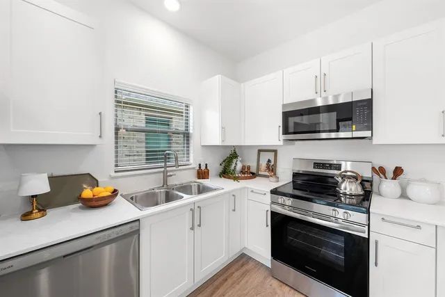 a kitchen with a sink stove top oven and cabinets