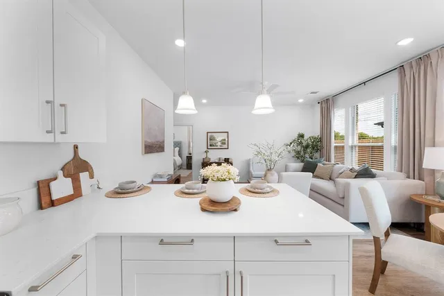 a kitchen with kitchen island a white counter top space and living room view