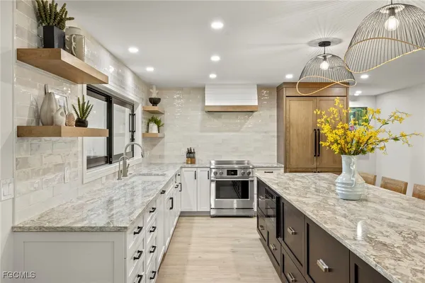 a kitchen with stainless steel appliances granite countertop a sink and a stove