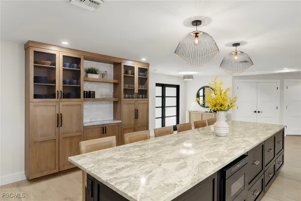 a kitchen with granite countertop a table chairs in it and wooden floors