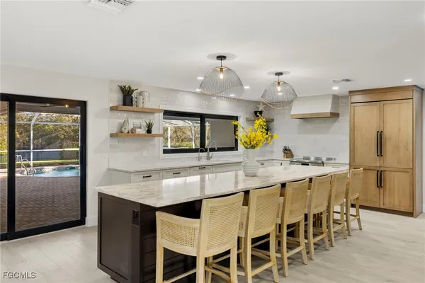 a kitchen with stainless steel appliances granite countertop counter space and chairs in it