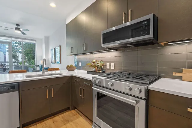 a kitchen with stainless steel appliances a sink dishwasher stove and microwave