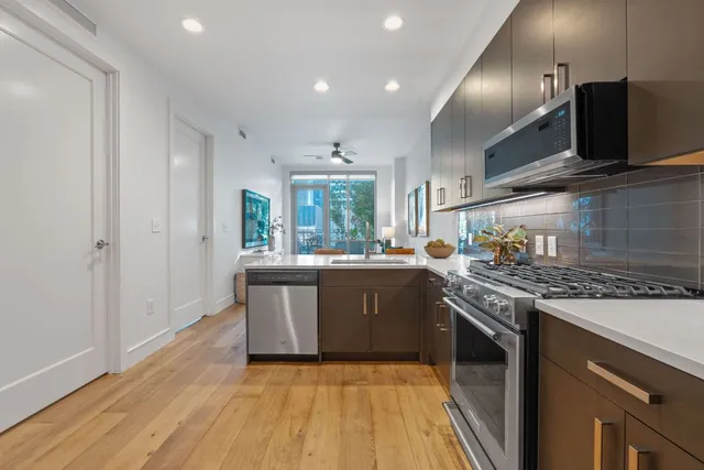 a kitchen with stainless steel appliances granite countertop a stove and a sink