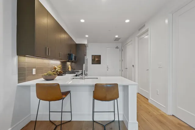 a kitchen with cabinets and chairs