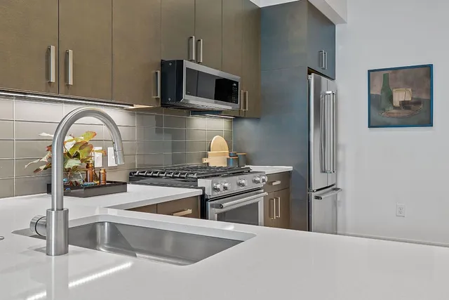 a kitchen with stainless steel appliances granite countertop a sink and a stove