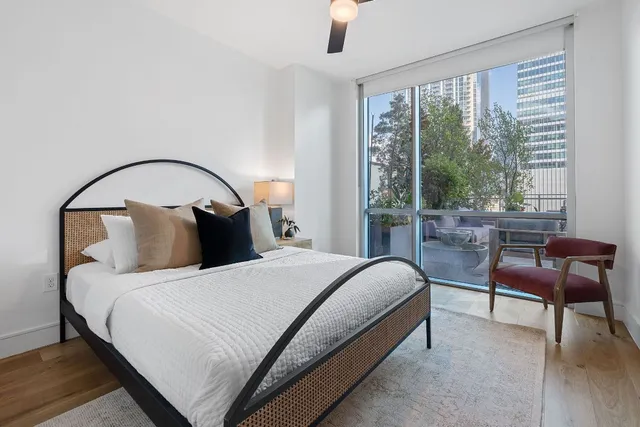 a bedroom with a bed chair and a large window