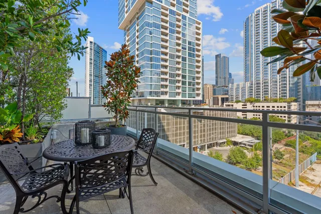 a view of a balcony with dining table and chairs