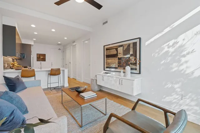 a living room with furniture a flat screen tv and kitchen view