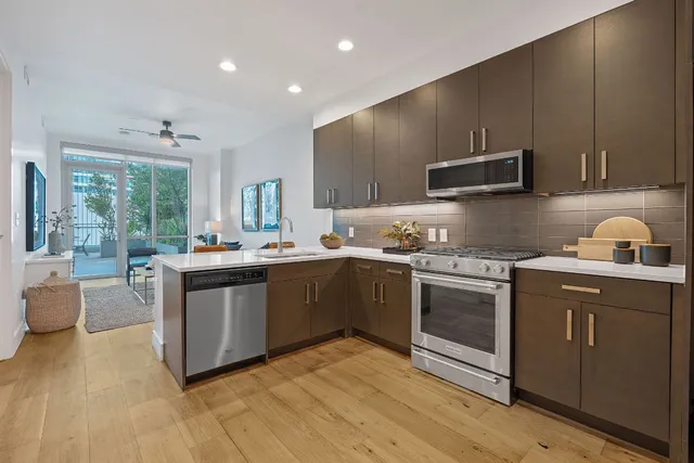 a kitchen with stainless steel appliances granite countertop a sink and a stove top oven