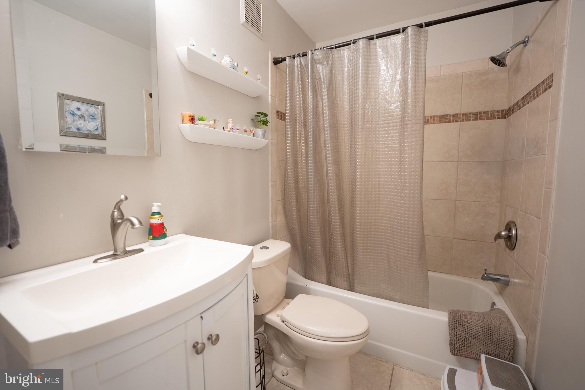 15 Pickering Court, Unit 1502 Germantown, MD 20874 - Photo 16 of 17 a bathroom with a sink a toilet and shower curtain