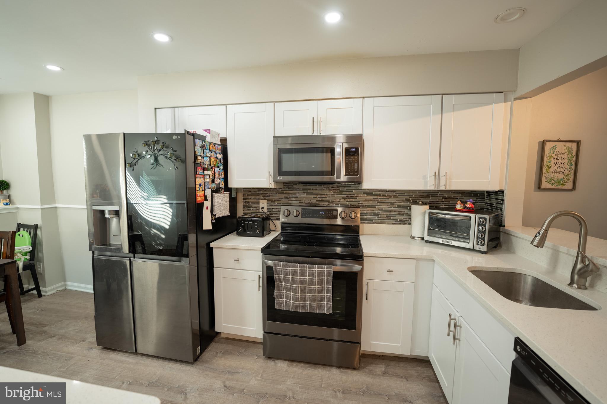 15 Pickering Court, Unit 1502 Germantown, MD 20874 - Photo 6 of 17 a kitchen with stainless steel appliances granite countertop a refrigerator stove and sink