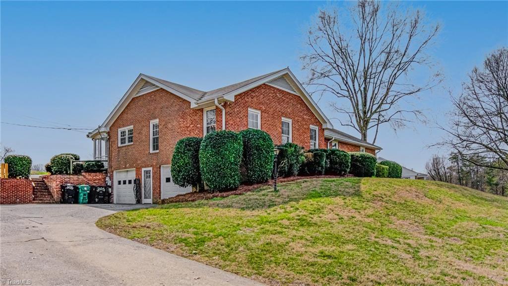 305 Pine Ridge Drive High Point, NC 27262 - Photo 2 of 35 Ranch style home with brick exterior, paved driveway, basement garage, and large front yard.
