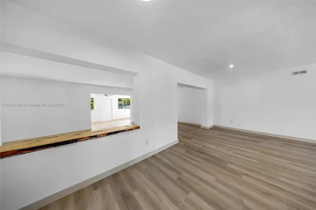 a view of a room with wooden floor and window