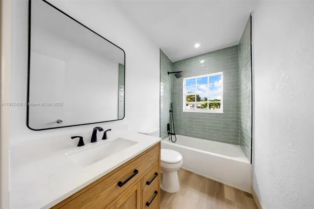 a bathroom with a tub sink toilet and mirror