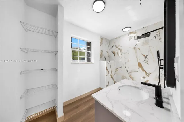 a bathroom with a granite countertop sink a mirror and shower