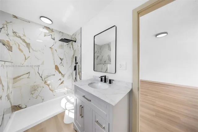 a bathroom with a sink toilet vanity and shower