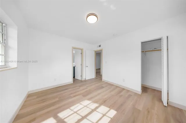 a view of a room with wooden floor and window