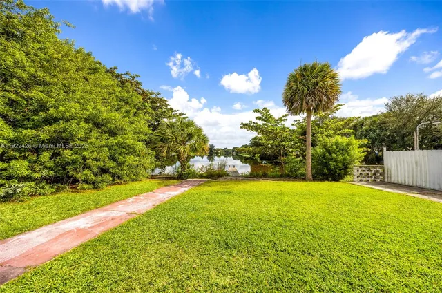 a view of yard with swimming pool and green space