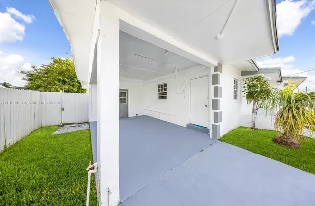 a view of a house with a yard and palm trees