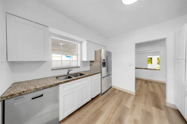 a kitchen with granite countertop a sink and cabinets