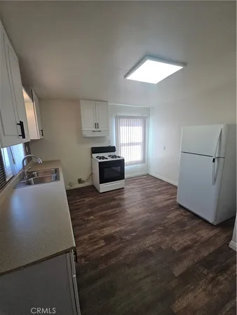 a kitchen with a wooden floor and a stove top oven
