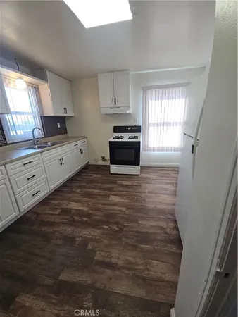 a kitchen with granite countertop white cabinets and white appliances